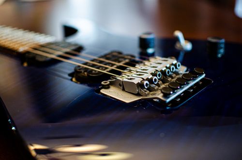 Free Detailed close-up of an electric guitar's bridge showcasing strings and tuning pegs. Stock Photo