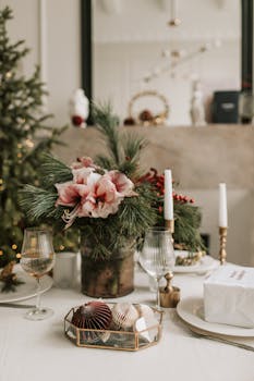 A beautifully arranged Christmas table setting featuring a floral centerpiece and decorative elements.