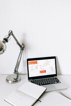 A sleek workspace featuring a laptop displaying data analysis charts, perfect for business and technology themes.