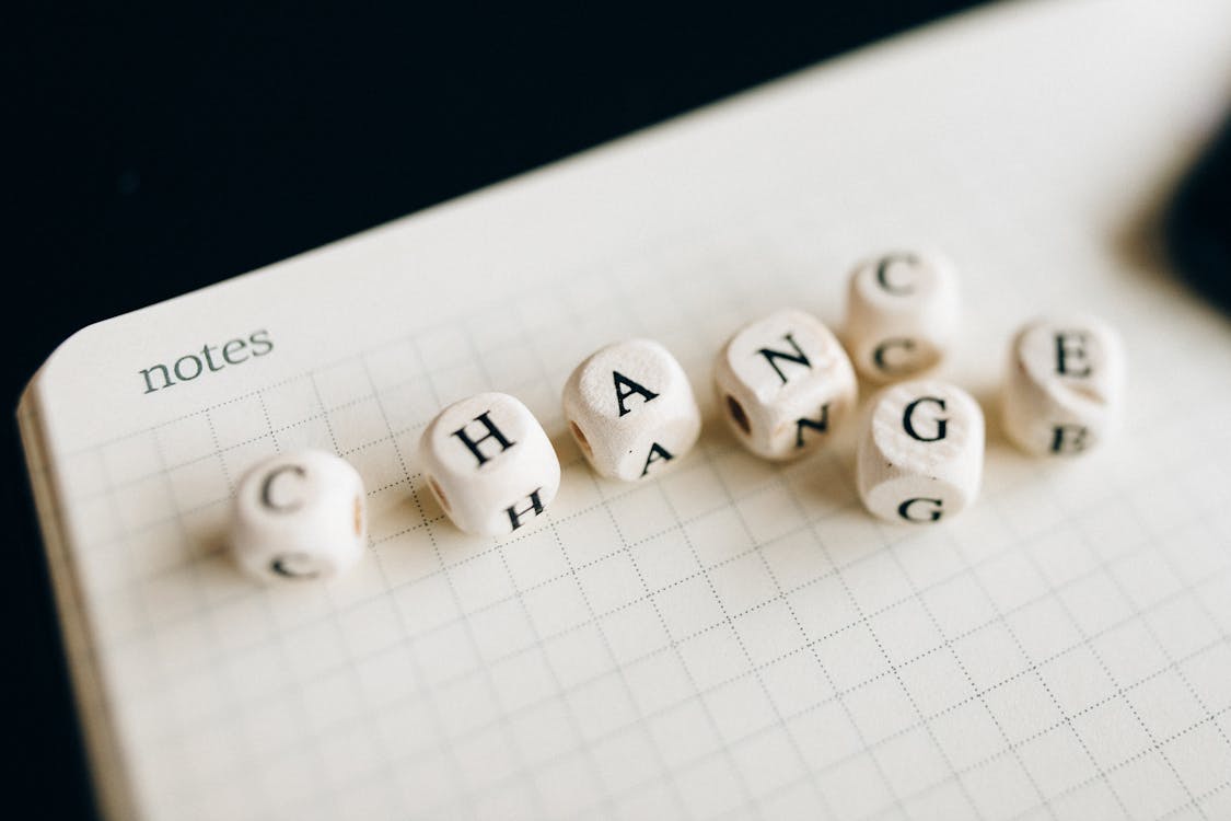 Free A Close-Up Shot of Letter Dice on an Open Notebook Stock Photo