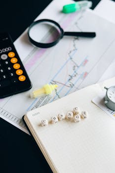 Close-up of financial tools and letter blocks spelling 'CHANGE'.