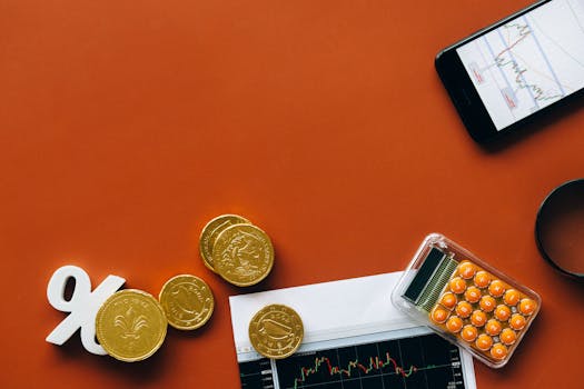 Flat lay showing coins, calculator, and charts on a red background for financial analysis and business concepts.