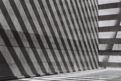 Free Black and white abstract shot of geometric shadows cast on a modern urban wall. Stock Photo
