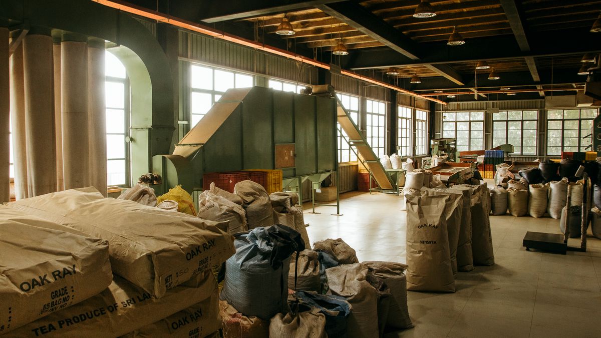 Sacks of made tea printed with the garden name stacked in the packing room of a tea factory in Sri Lanka