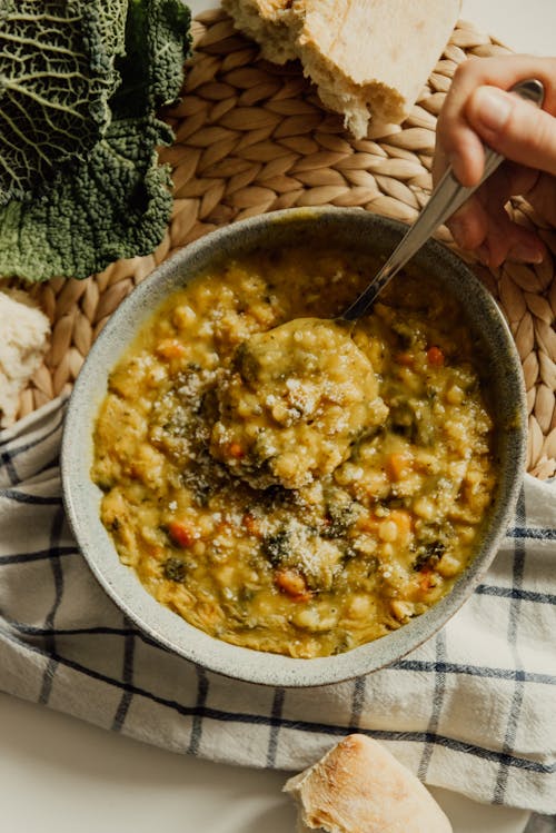 Persona Sosteniendo Una Cuchara De Acero Inoxidable Y Un Cuenco De Cerámica Blanca Con Arroz