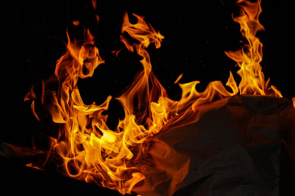 Close-up shot of roaring fire flames against a dark background, highlighting heat and energy.
