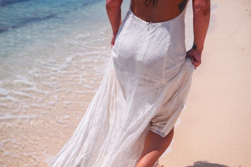 Free Woman in White Dress Walking at the Beach Stock Photo
