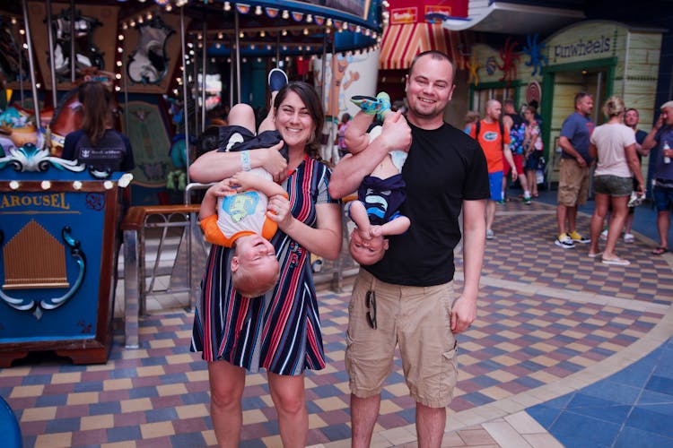 
Parents Carrying Their Children Upside Down In An Amusement Park