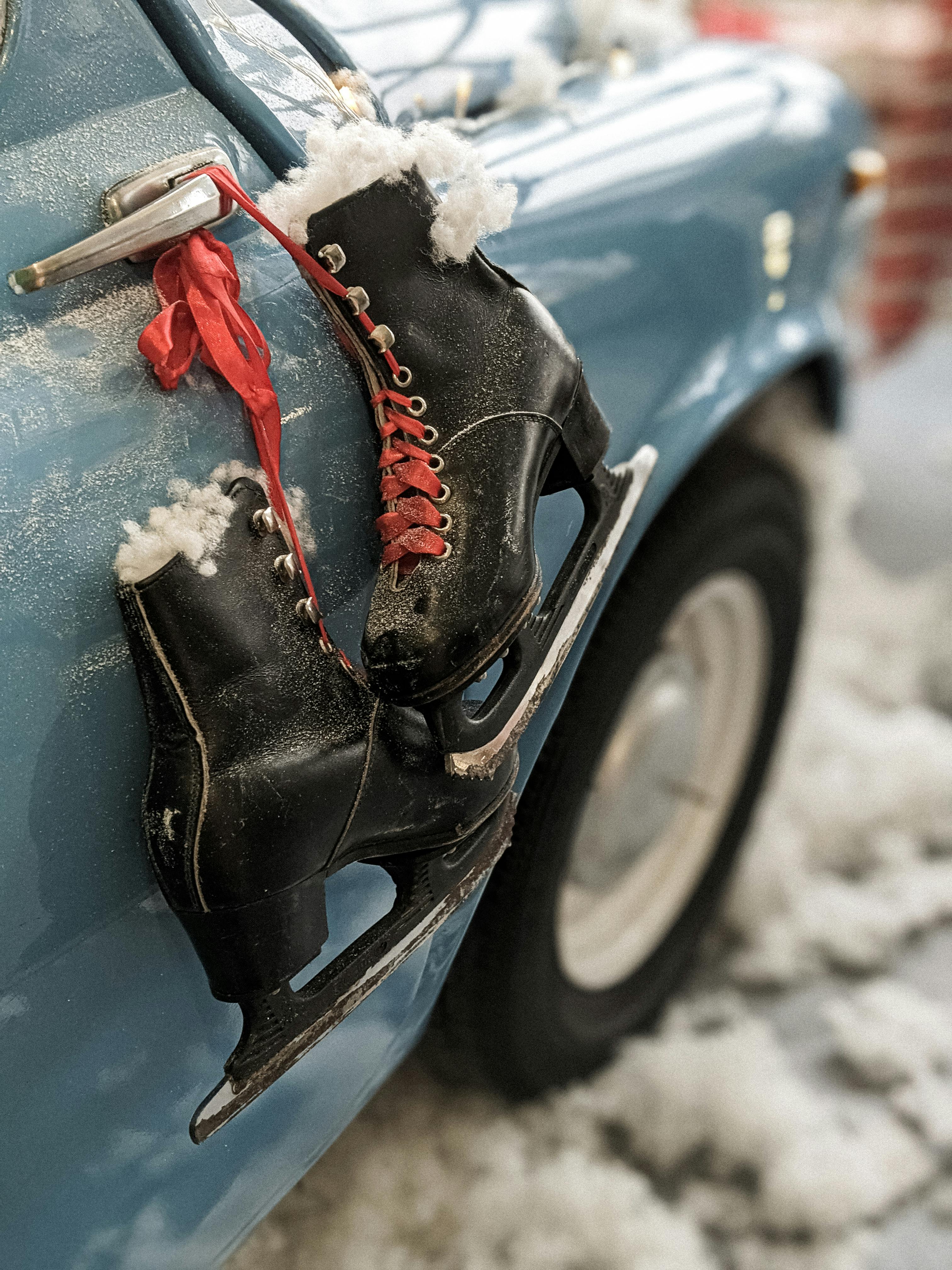 a black ice skates hanging on a cars dorr handle