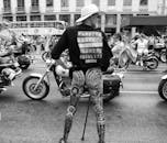 Grayscale Photo of Man in Black T-shirt and Cowboy Hat Riding Motorcycle