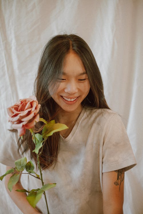 Happy Asian woman with rose smiling