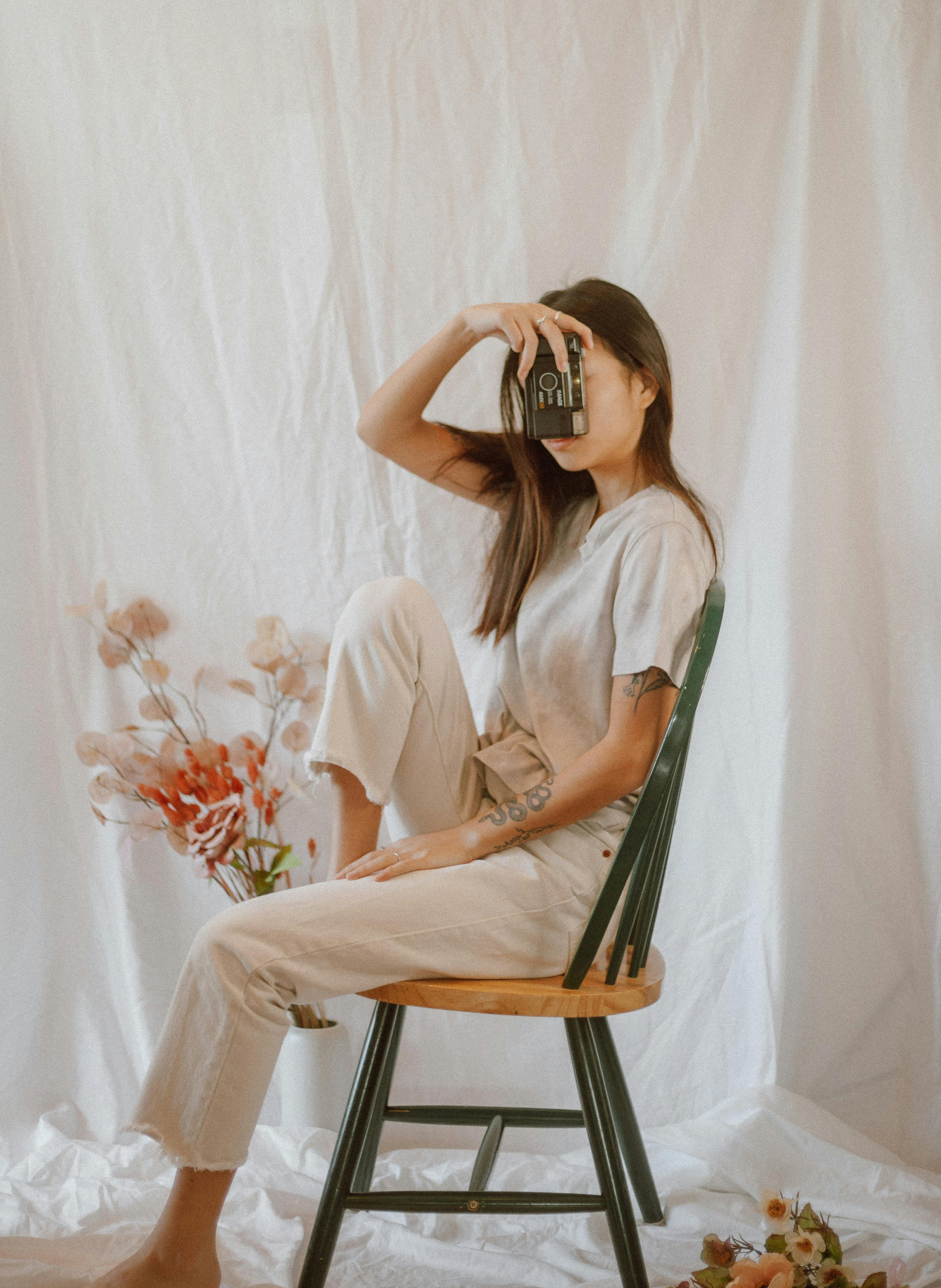 slim woman with vintage photo camera on chair