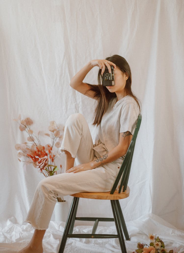 Slim Woman With Vintage Photo Camera On Chair