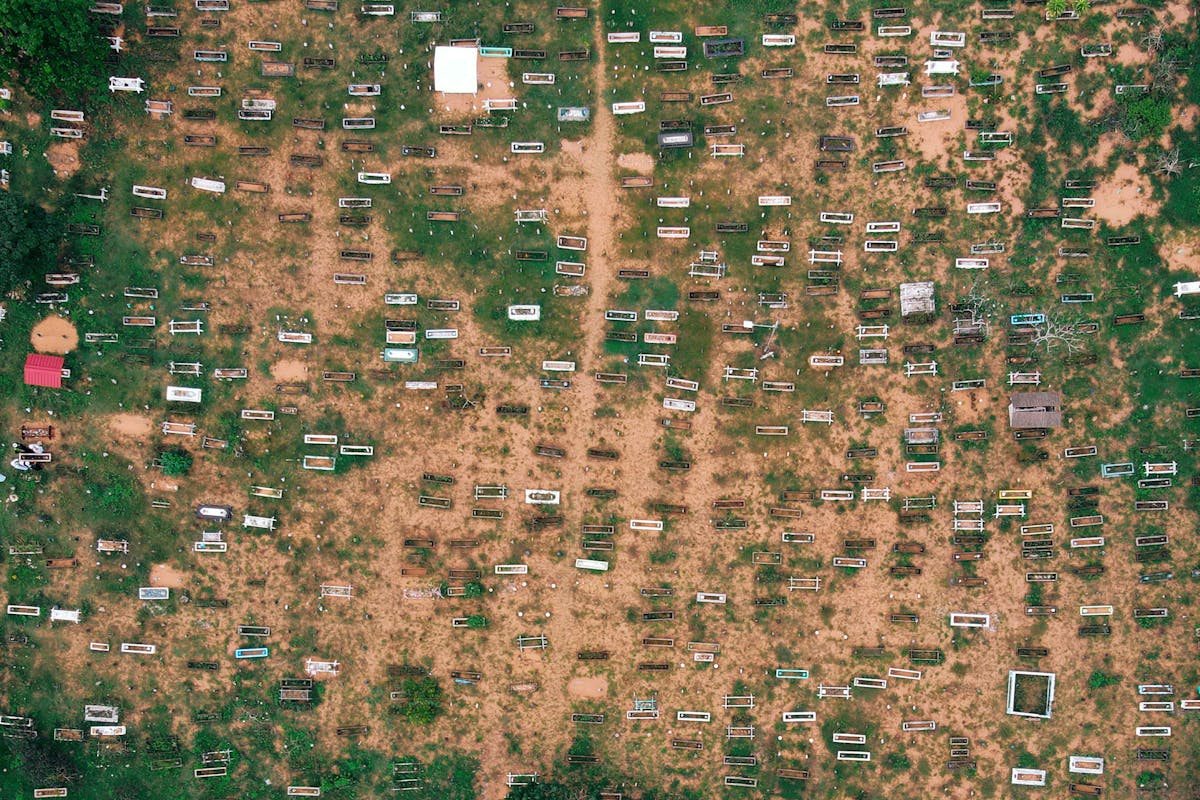Top view of small trailers and shabby houses in poor suburbs of countryside on sandy terrain in daytime