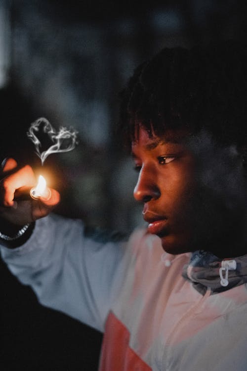 Black male burning smoke with lighter