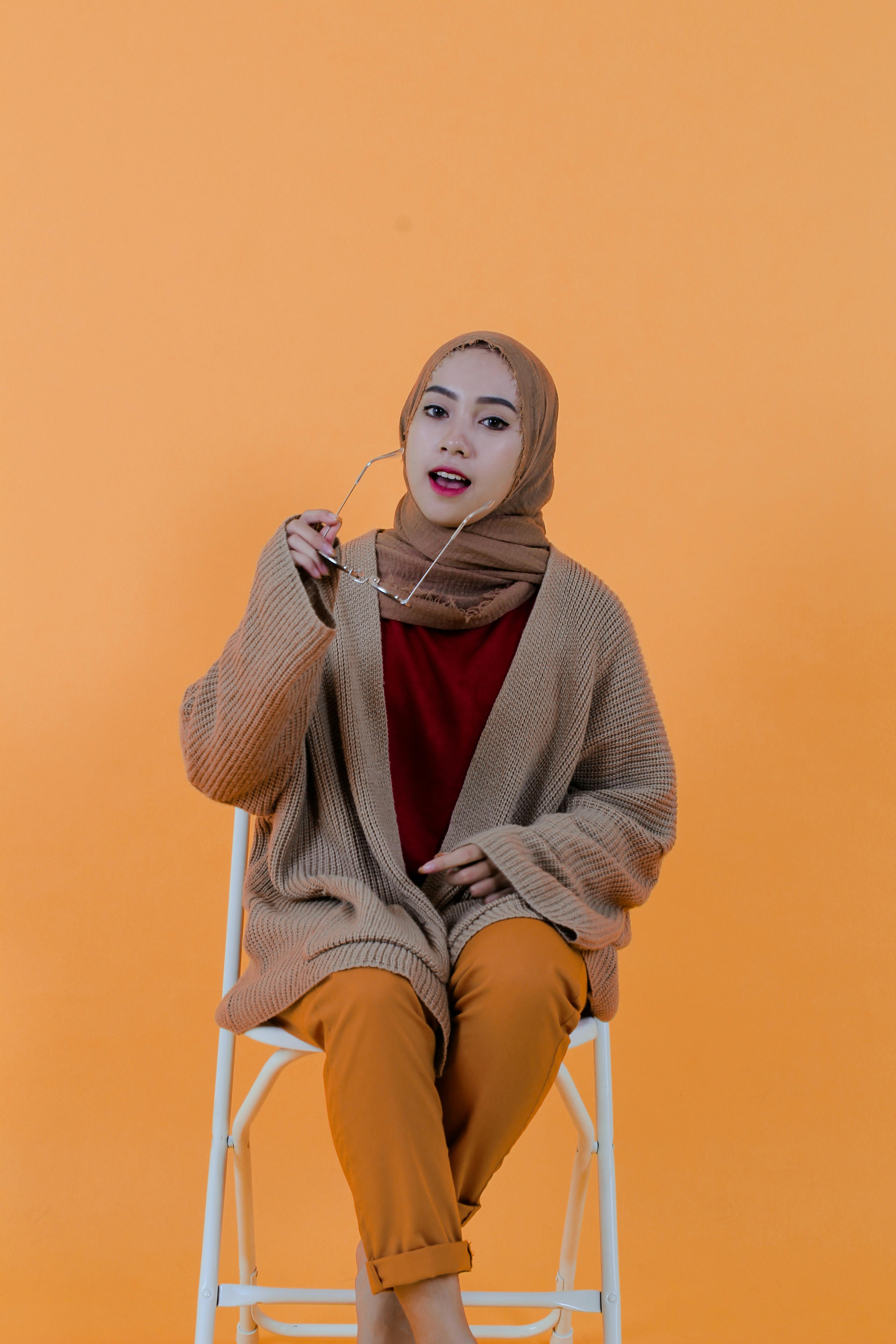 Stylish content Islamic woman putting on sunglasses in studio · Free