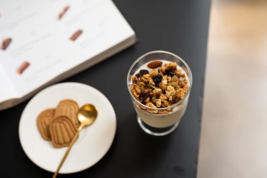 Delicious granola parfait served with cookies and a menu backdrop for a cozy breakfast setting.