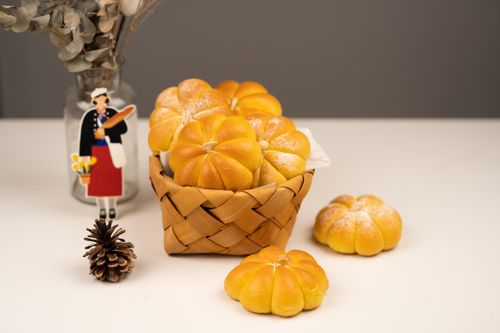 Free Delicious freshly baked pumpkin-shaped buns in a basket, perfect for an autumn feast. Stock Photo