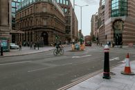Man in Black Jacket Riding Bicycle on Road