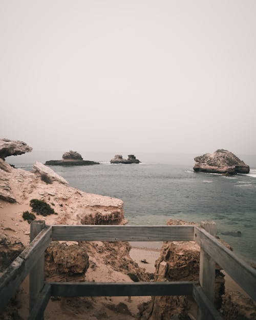 Brown Wooden Fence on Rocky Cliff