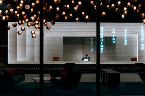 Free A stylish office lobby featuring pendant lighting and reflection effects in modern interior design. Stock Photo