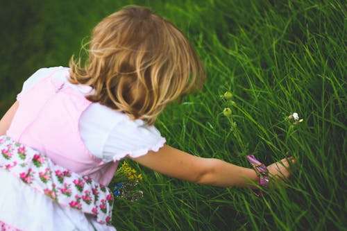 Little girl breaks the flowers