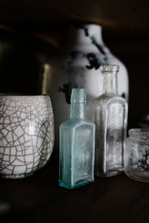 Free A close-up of vintage glass bottles and a ceramic vase with intricate textures, perfect for interior design themes. Stock Photo