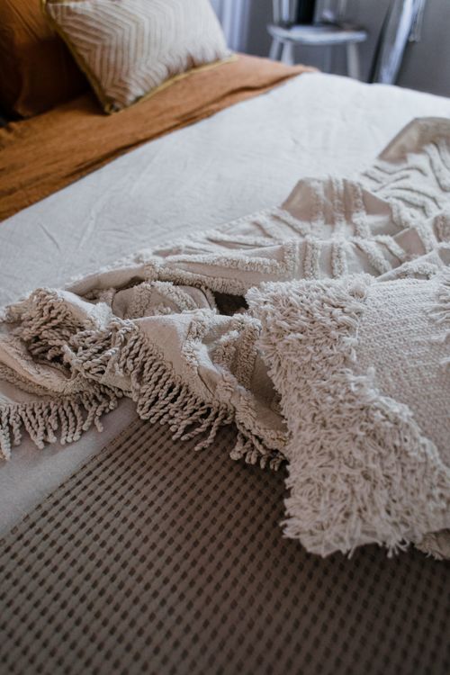 Free Close-up of textured knit and linen blankets on an indoor bed setting. Stock Photo