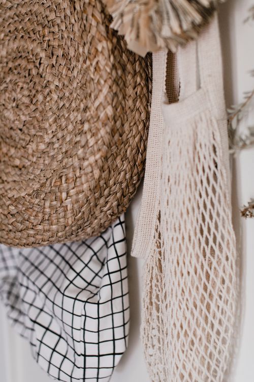 Free Rustic wall decor featuring a woven hat, checkered cloth, and mesh bag for a warm, cozy atmosphere. Stock Photo