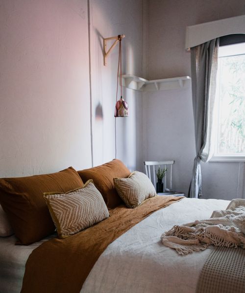 Free Modern bedroom featuring warm tones, natural light, and minimalist decor for a cozy atmosphere. Stock Photo