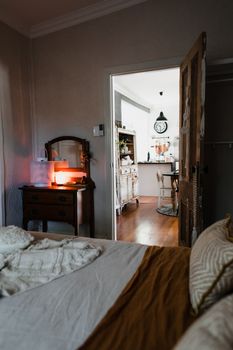 Warm and inviting bedroom with vintage furniture and open door view.