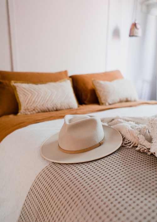 Free Contemporary bedroom design featuring a fedora on plush bedding for added style. Stock Photo