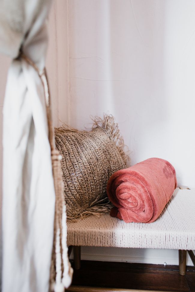 Neutral woven blanket and soft pillow in a serene bedroom