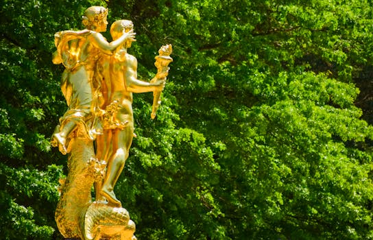 公园里，一座描绘神话人物的金色雕像矗立在鲜艳的绿叶背景中