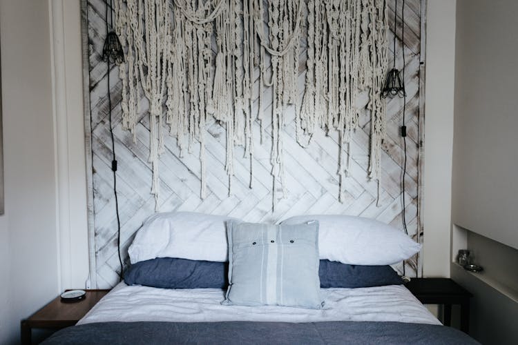 Bed With Wooden Headboard And Ropes Hanging