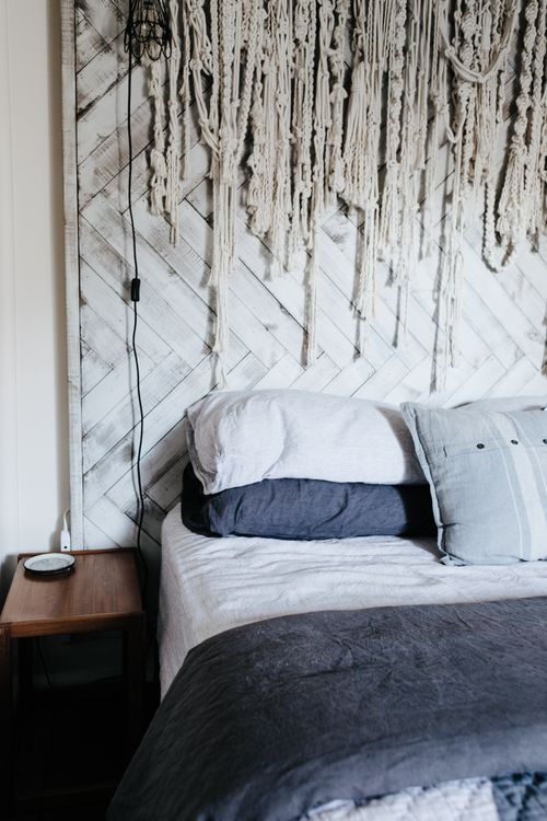 Free Stylish bedroom with macramé decor and layered pillows for a cozy feel. Stock Photo