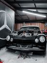 Jacked Up Black Classic Car with Missing Hood