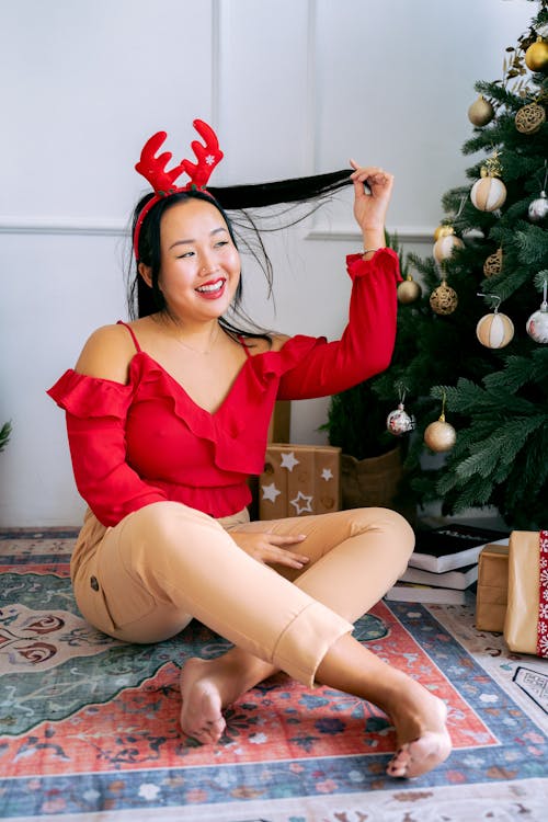 Woman in Red Off Shoulder Long Sleeves Wearing Reindeer Antler Headband