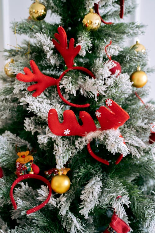 Red and Gold Baubles on Snowy Christmas Tree