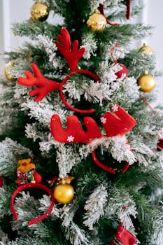 Brightly decorated Christmas tree with festive snow and ornaments, perfect for holidays.