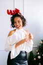 Woman with Red Reindeer Antlers Headband Holding Clear Glass
