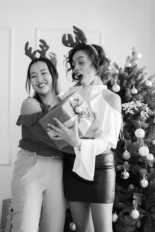 Women Standing Close with Christmas Present