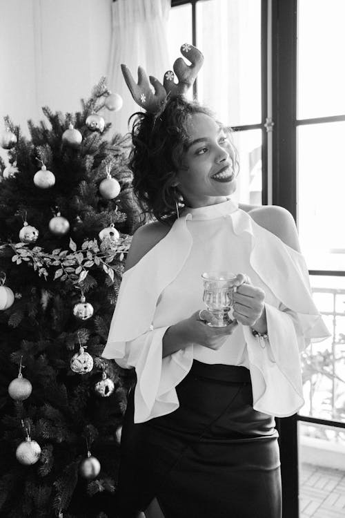 Grayscale Photo of Woman in White Long Sleeve Shirt Holding Clear Drinking Glass