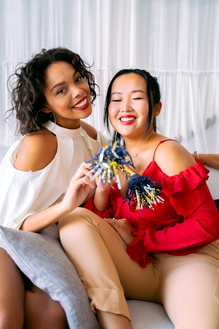 Smiling Women Holding Party Horns