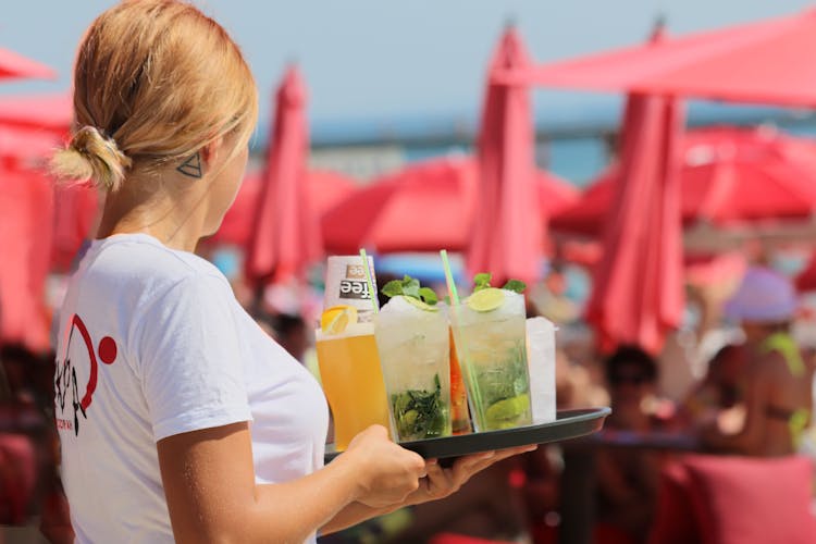 A Waitress Carrying A Tray Of Cocktail Drinks