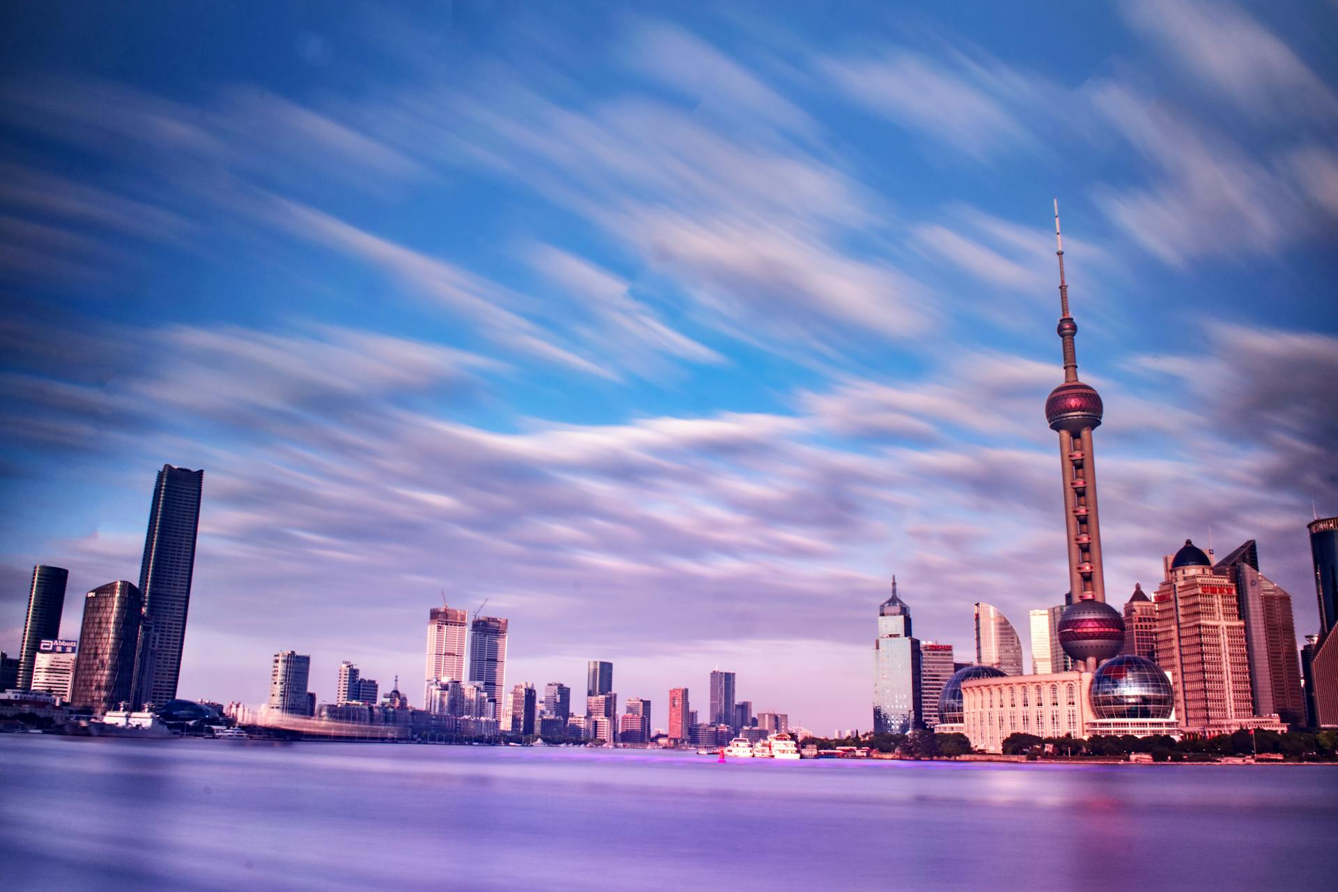 Vibrant Shanghai skyline at day, featuring iconic skyscrapers and a dynamic sky.