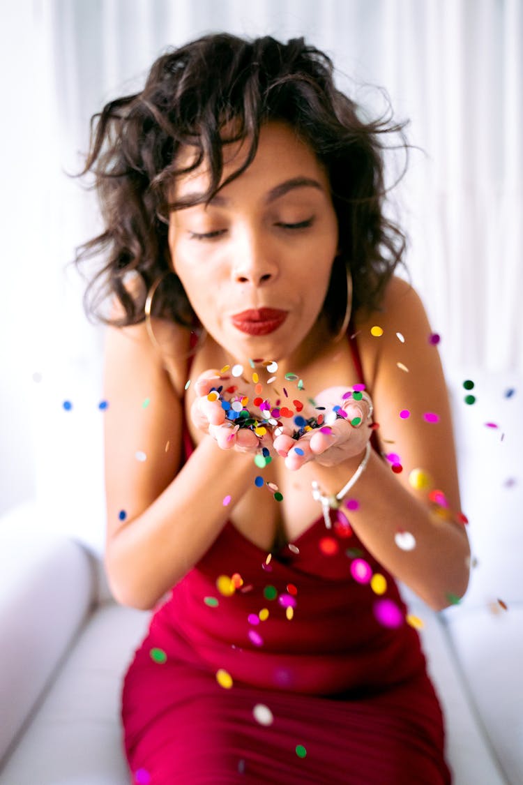 Woman Blowing The Confetti On Her Hands 