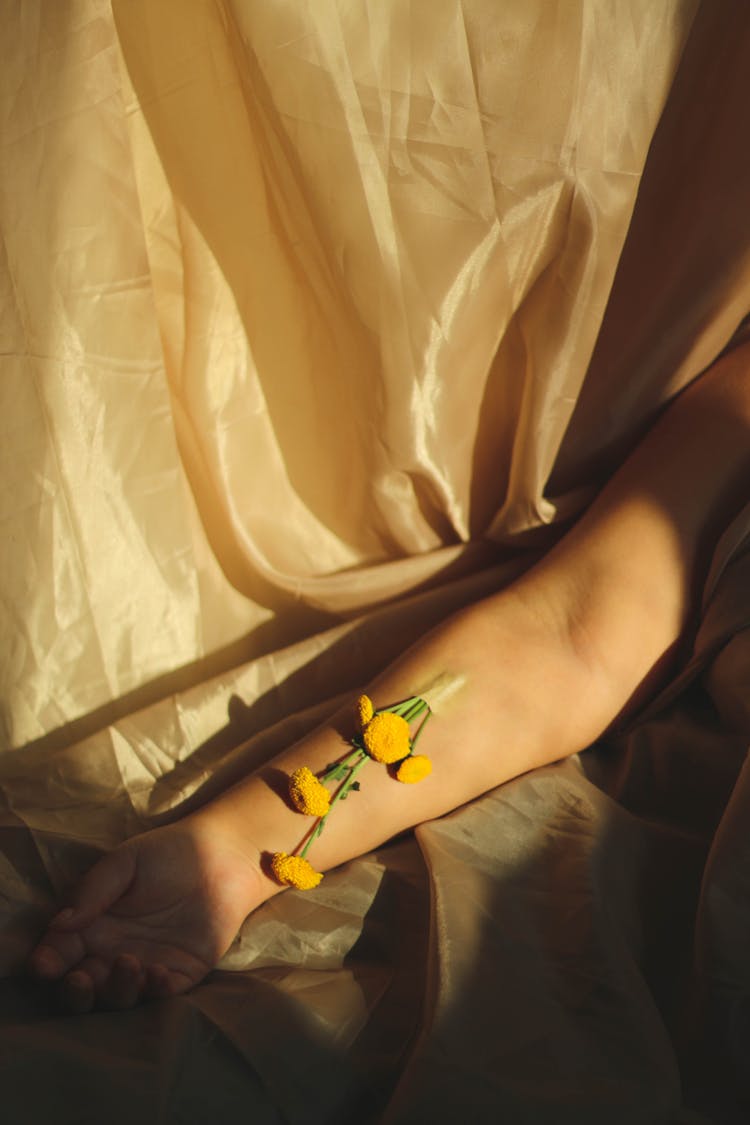 Yellow Flowers Taped On A Person's Arm