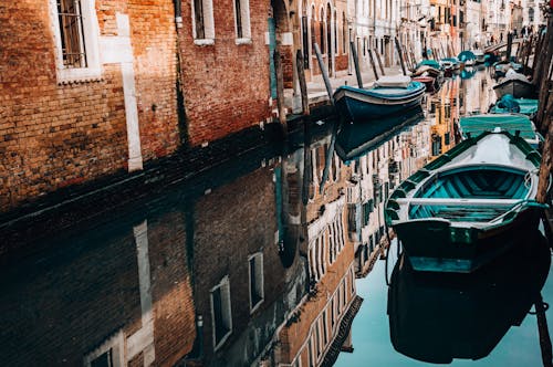 Reflection of Buildings and Boats on Water Surface