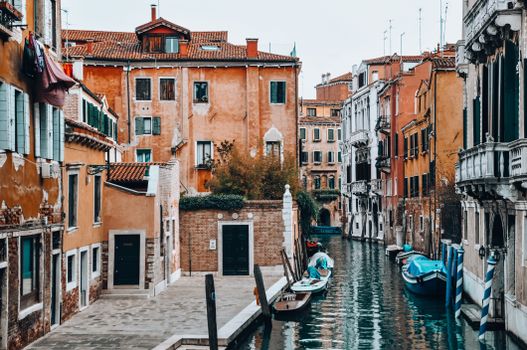 Scenic view of a Venetian canal lined with historic buildings and boats, showcasing Venice's iconic architecture.